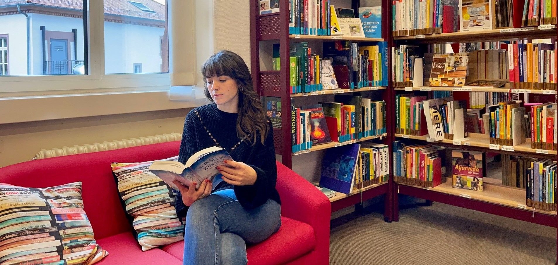 Eine Frau sitzt  in der Leseecke und liest.