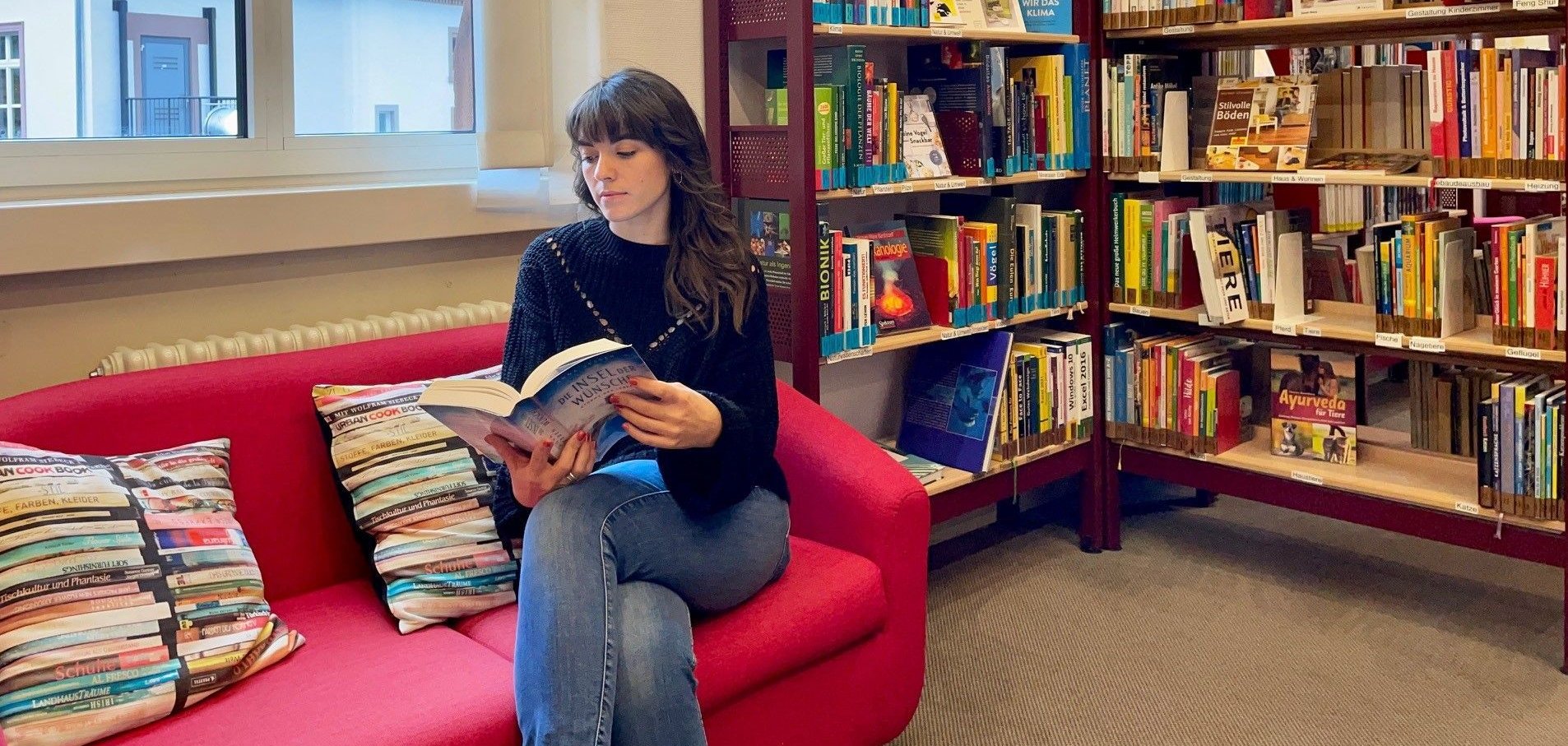 Eine Frau sitzt  in der Leseecke und liest.