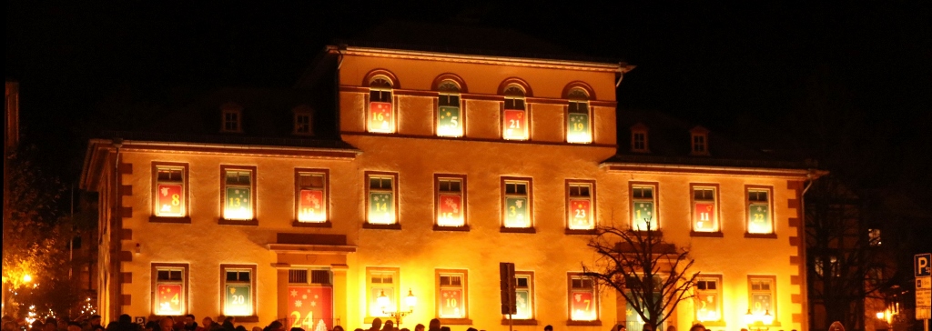 Riesiger Adventskalender Die ehemalige Bürgerschule am Obermarkt in Gelnhausen bei Nacht. Die 24 Fenster illuminieren die mit Licht hinterlegten, von Kinderhand gemalten Motive des Adventskalenders.