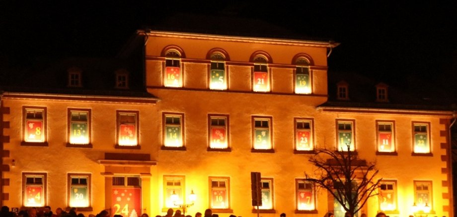 Riesiger Adventskalender Die ehemalige Bürgerschule am Obermarkt in Gelnhausen bei Nacht. Die 24 Fenster illuminieren die mit Licht hinterlegten, von Kinderhand gemalten Motive des Adventskalenders.