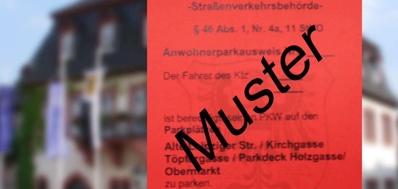 Parkausweis Ein Muster des roten Anwohnerparkausweises vor dem Rathaus.