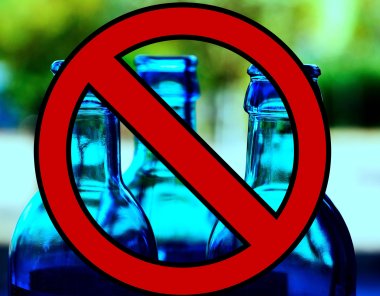 Symbolbild mit Verbotszeichen und Glasflaschen im Hintergrund.