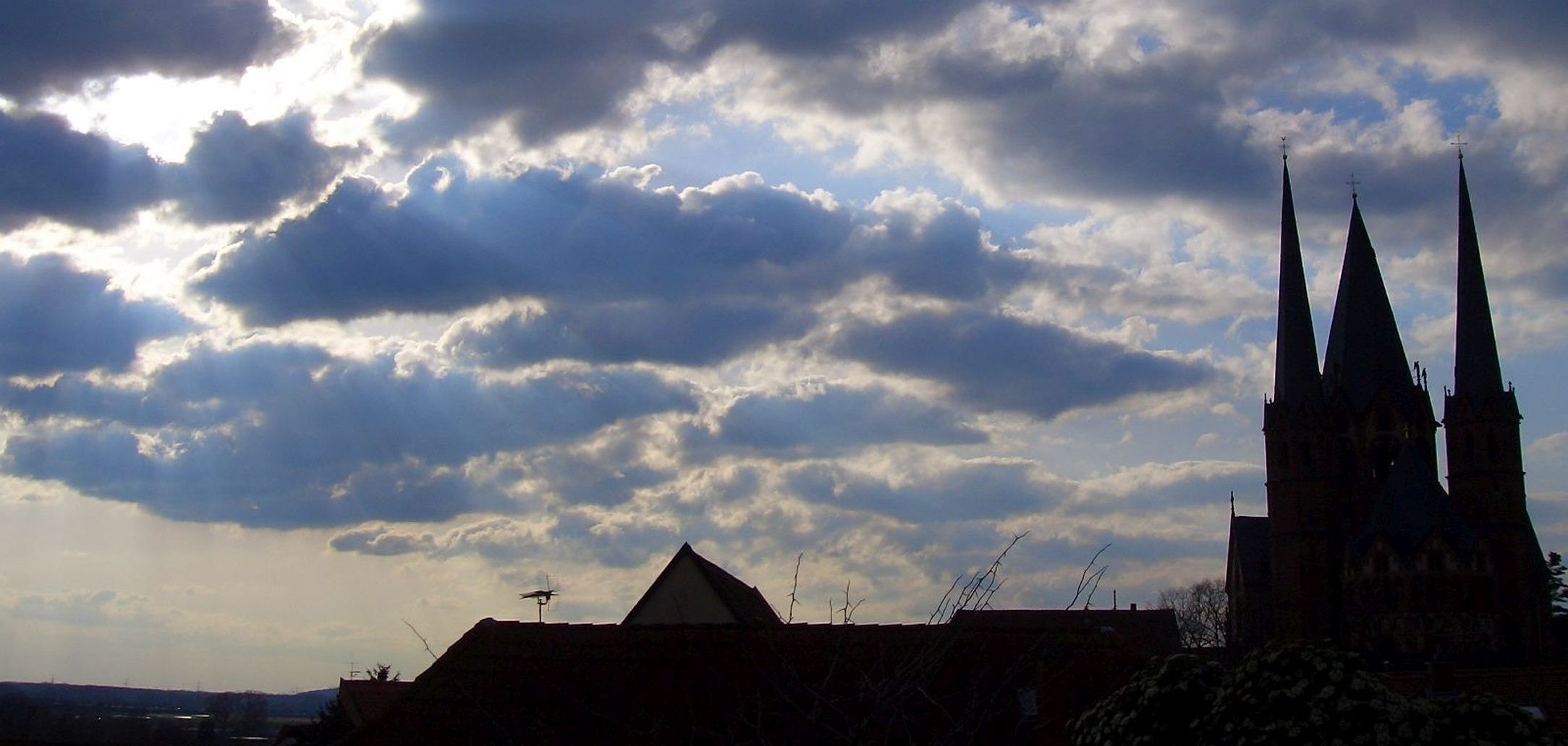 Hageltag Symbolfoto zum Gelnhäuser Gedenktag Hageltag. Es zeigt die schwarze Silhouette der Marienkirche über der ein Gewitter heraufzieht.