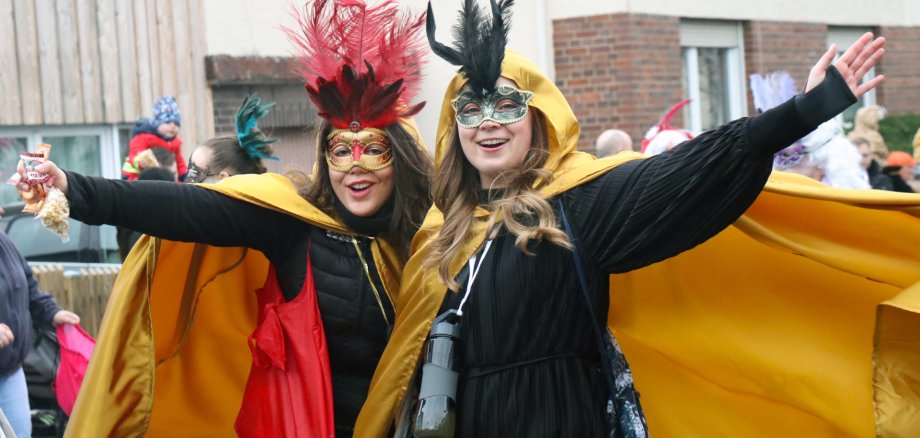 Zwei fröhliche Damen mit Masken.