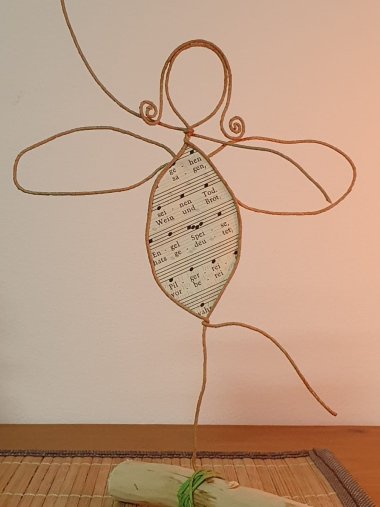 Papier Werkstatt Man sieht eine abstrakte Darstellung einer Frau mit Flügeln, die aus Papier gebastelt wurden