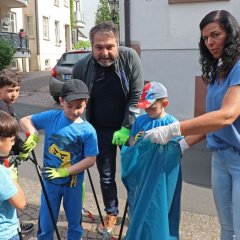 Kita-Leiterin Kerstin Rott (rechts) und Bürgermeister Glöckner halten Müllsäcke bereit. Die Kita-Kinder befördern den gesammelten Abfall hinein.